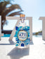 4711 Remix Sparkling Island steht vor weißem 4711 Logo in der Sonne